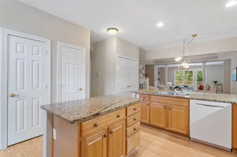 a dining hall with stainless steel appliances granite countertop a sink a stove and a refrigerator