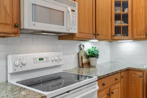 a view of kitchen with stainless steel appliances granite countertop cabinets and window