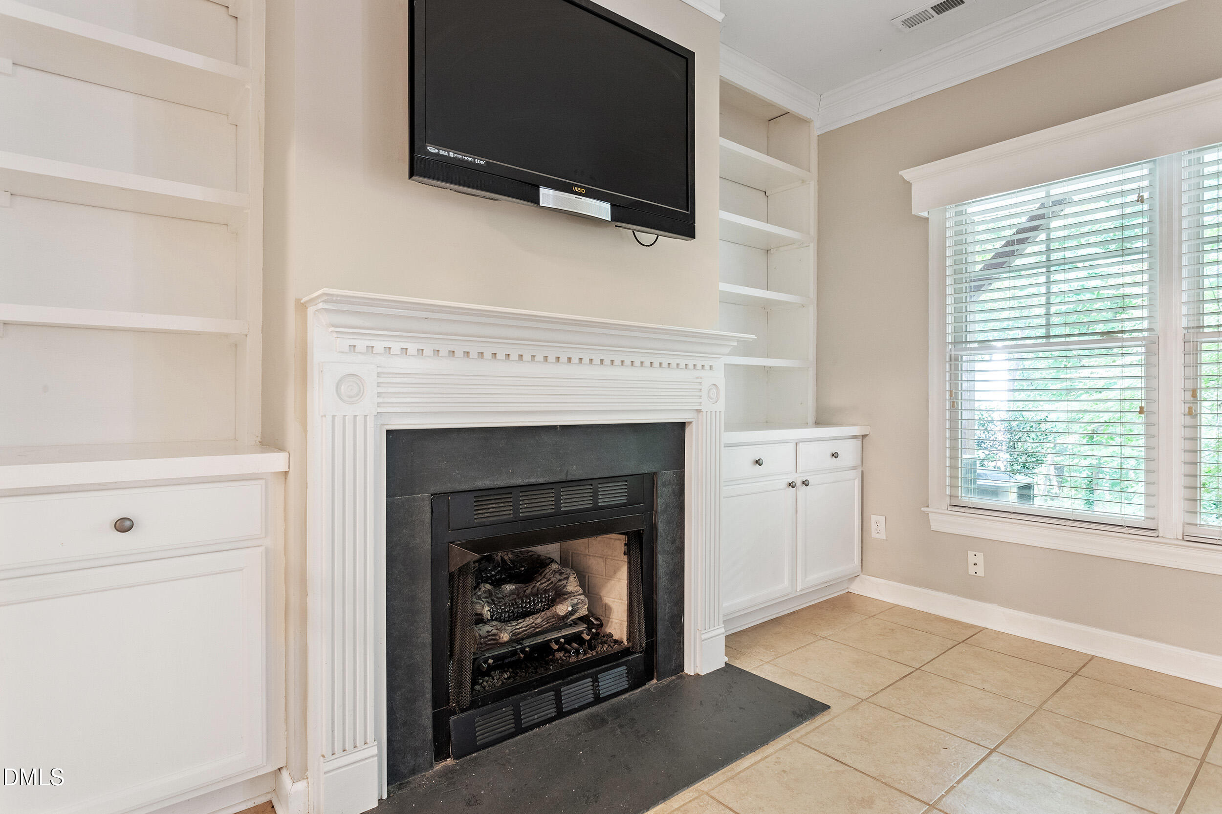4724 Ludwell Branch Court Raleigh, NC 27612 - Photo 63 of 72 a living room with a fireplace and a flat screen tv