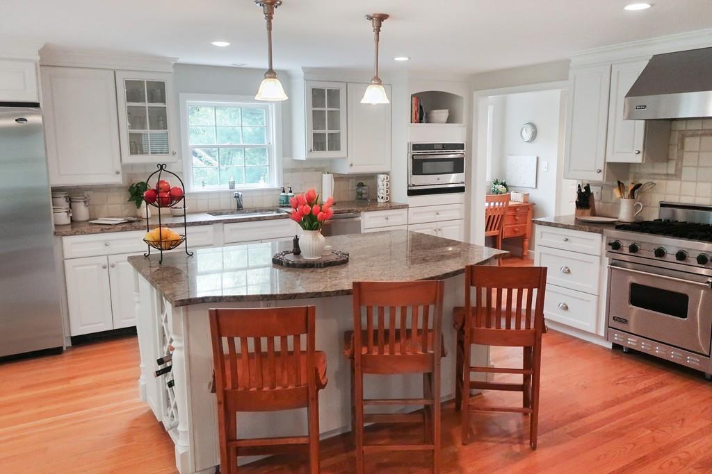 11 Prospect Hill Road Lexington, MA 02421 - Photo 5 of 24 a kitchen with stainless steel appliances granite countertop a stove a sink dishwasher a dining table and chairs with wooden floor