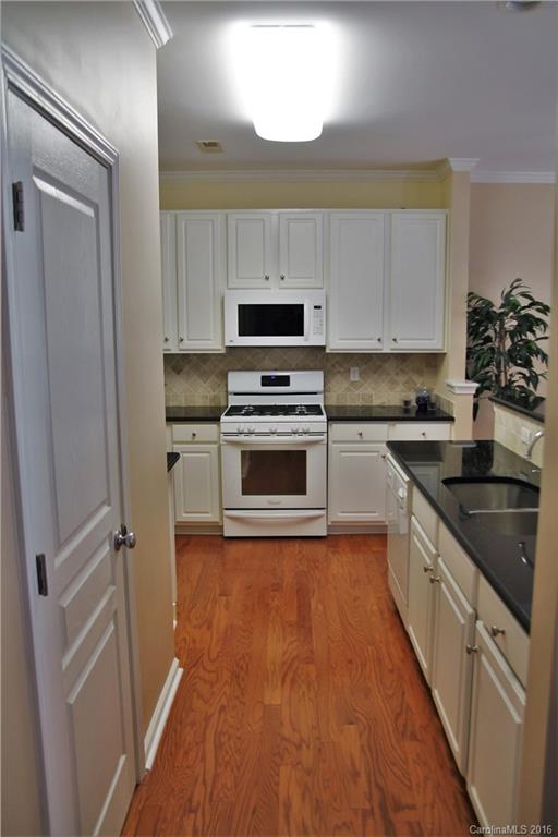 3908 Caliper Place, Unit 325 Fort Mill, SC 29708 - Photo 8 of 24 a kitchen with granite countertop a sink a stove top oven and cabinetry