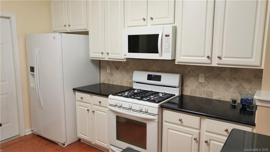 3908 Caliper Place, Unit 325 Fort Mill, SC 29708 - Photo 9 of 24 a kitchen with stainless steel appliances granite countertop white cabinets and a stove