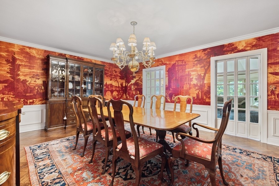 321 Oak Brook Road Oak Brook, IL 60523 - Photo 16 of 40 a view of a dining room with furniture a chandelier and wooden floor