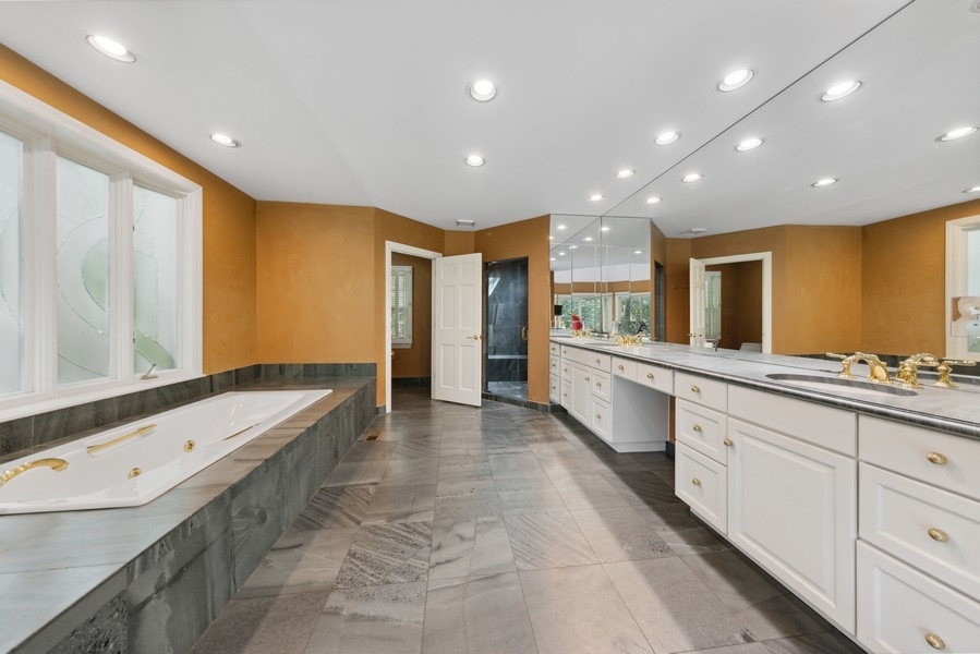 321 Oak Brook Road Oak Brook, IL 60523 - Photo 21 of 40 a bathroom with a tub sink and mirror