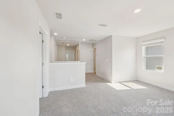 an empty room with a kitchen and a window