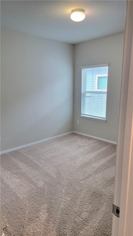 2741 Winding Creek Road Kyle, TX 78640 - Photo 7 of 11 Unfurnished room with light colored carpet and baseboards
