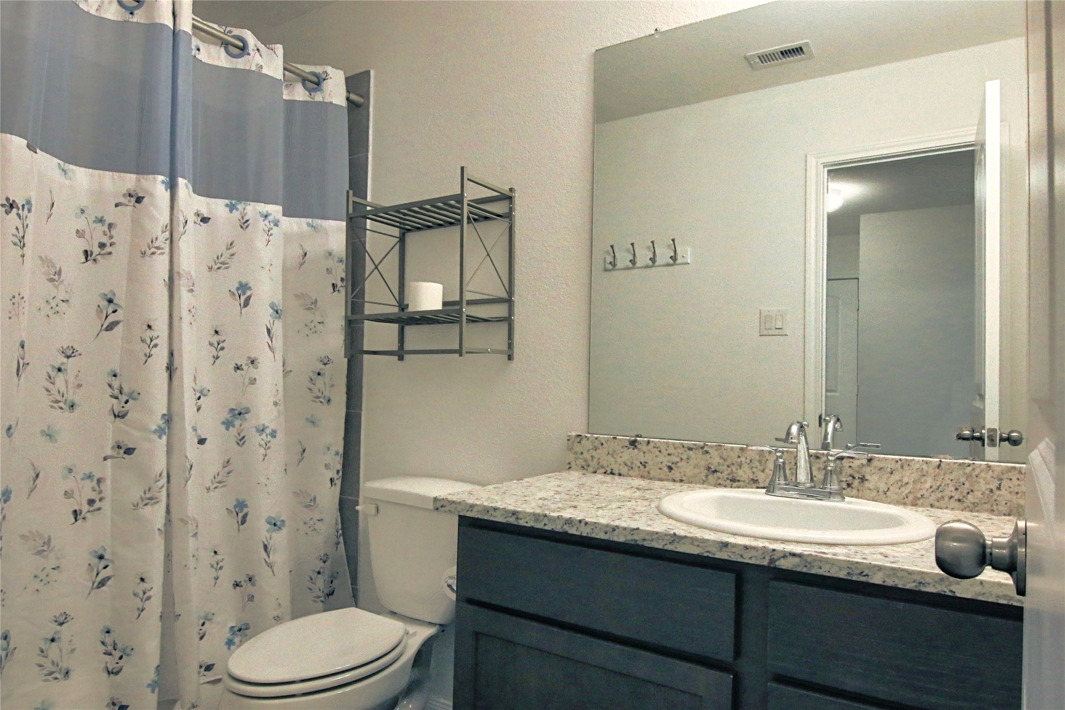 225 Basil Livingston, TX 77351 - Photo 16 of 22 a bathroom with a granite countertop sink toilet and shower