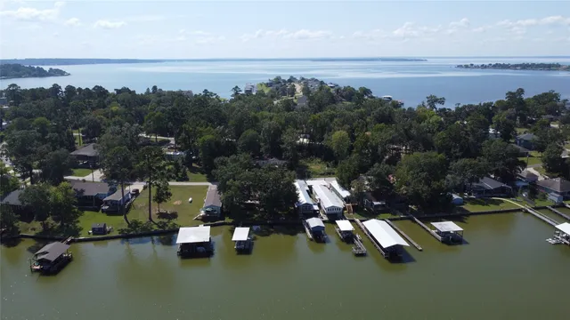 an aerial view of a house with a yard and lake view
