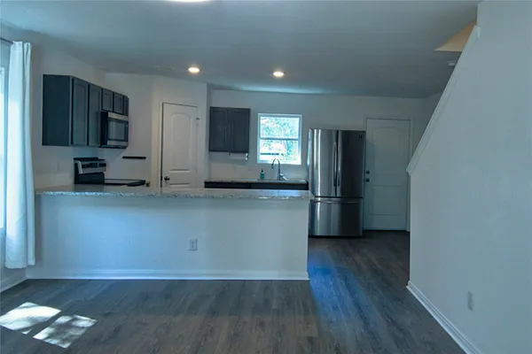 a kitchen with stainless steel appliances a refrigerator and a stove top oven