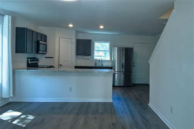 a kitchen with stainless steel appliances a refrigerator and a stove top oven