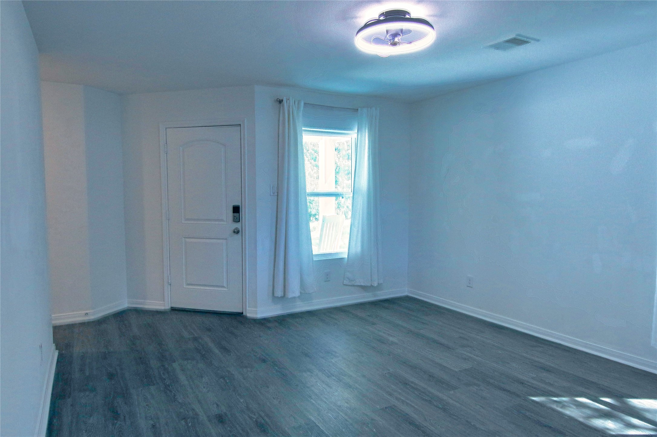 225 Basil Livingston, TX 77351 - Photo 5 of 22 an empty room with wooden floor and windows