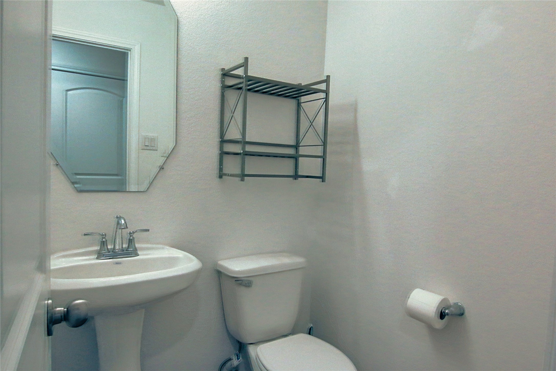 225 Basil Livingston, TX 77351 - Photo 6 of 22 a bathroom with a toilet a sink and mirror