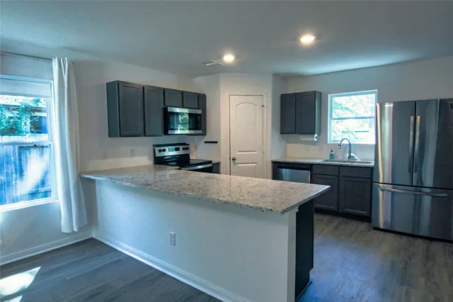 a kitchen with stainless steel appliances granite countertop a refrigerator and a sink