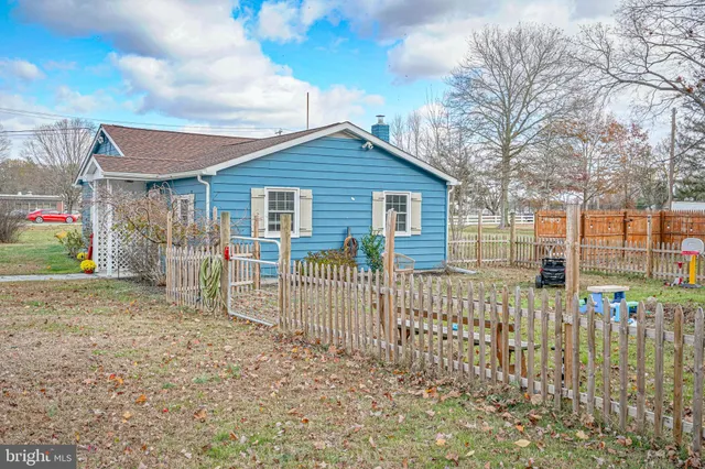 a view of a house with a small yard and wooden fence