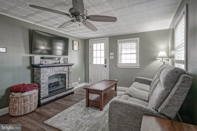 a living room with furniture a flat screen tv and a fireplace