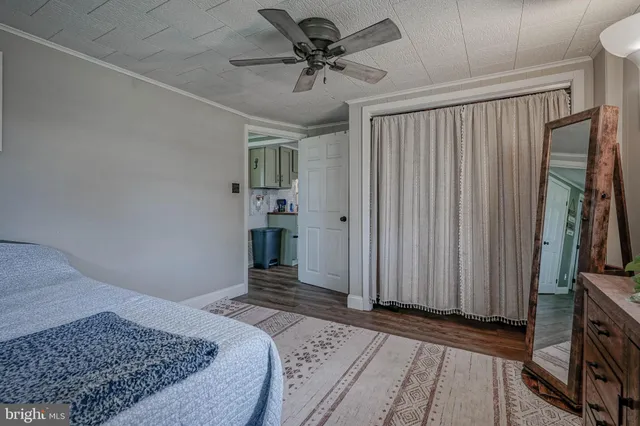 a view of a livingroom with a chandelier fan and wooden floor