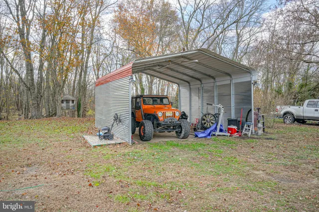 a view of a house with a car and large trees