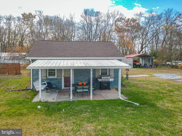 a view of a house with backyard porch and sitting area