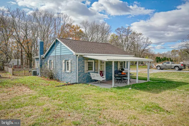 a view of a house with a yard and sitting area