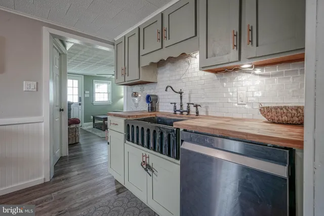 a kitchen with stainless steel appliances granite countertop a stove a sink and white cabinets