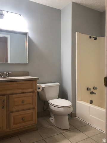 88 West 50 South, Unit B5 Centerville, UT 84014 - Photo 17 of 33 Bathroom with vanity, shower combination, light tile patterned floors, and a textured ceiling