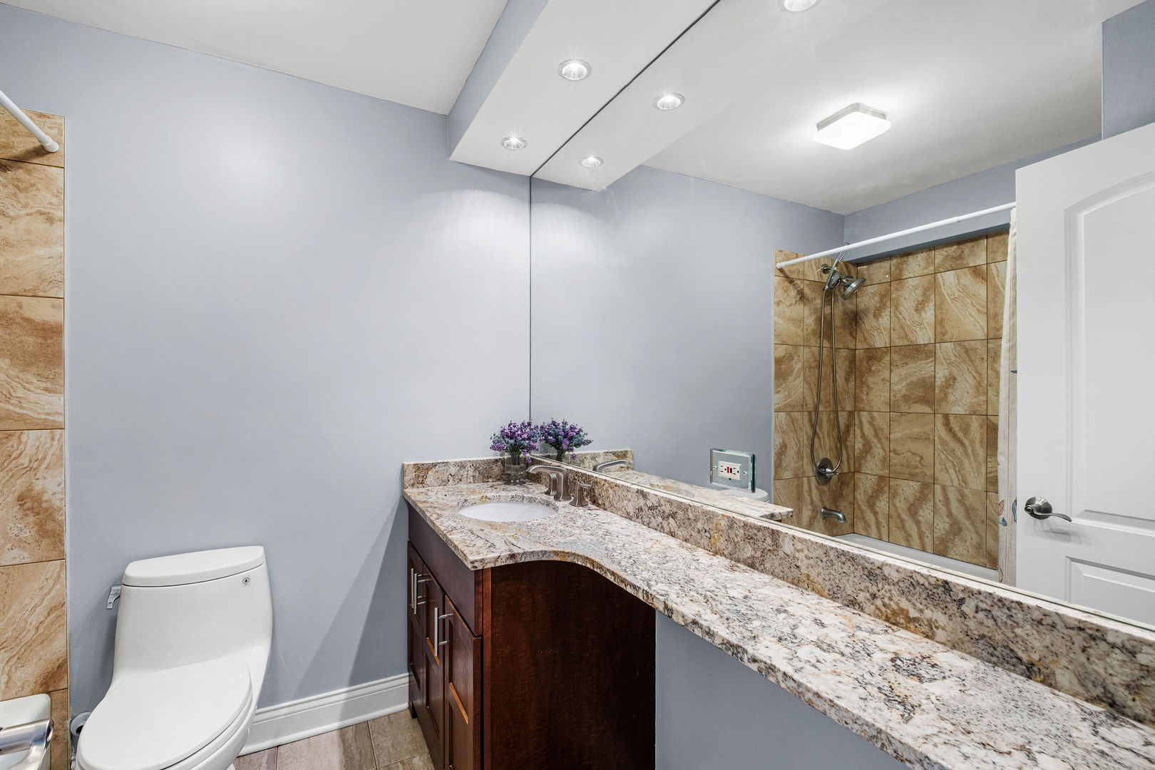 5455 North Sheridan Road, Unit 711 Chicago, IL 60640 - Photo 11 of 25 a bathroom with a granite countertop sink a mirror and a toilet
