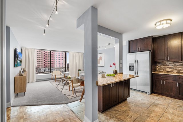 5455 North Sheridan Road, Unit 711 Chicago, IL 60640 - Photo 2 of 25 a kitchen with stainless steel appliances kitchen island granite countertop a refrigerator and stove