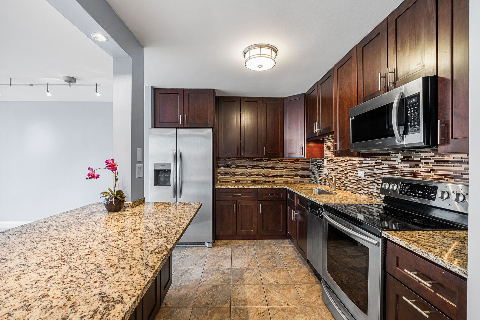 5455 North Sheridan Road, Unit 711 Chicago, IL 60640 - Photo 6 of 25 a kitchen with stainless steel appliances granite countertop a sink stove microwave and refrigerator