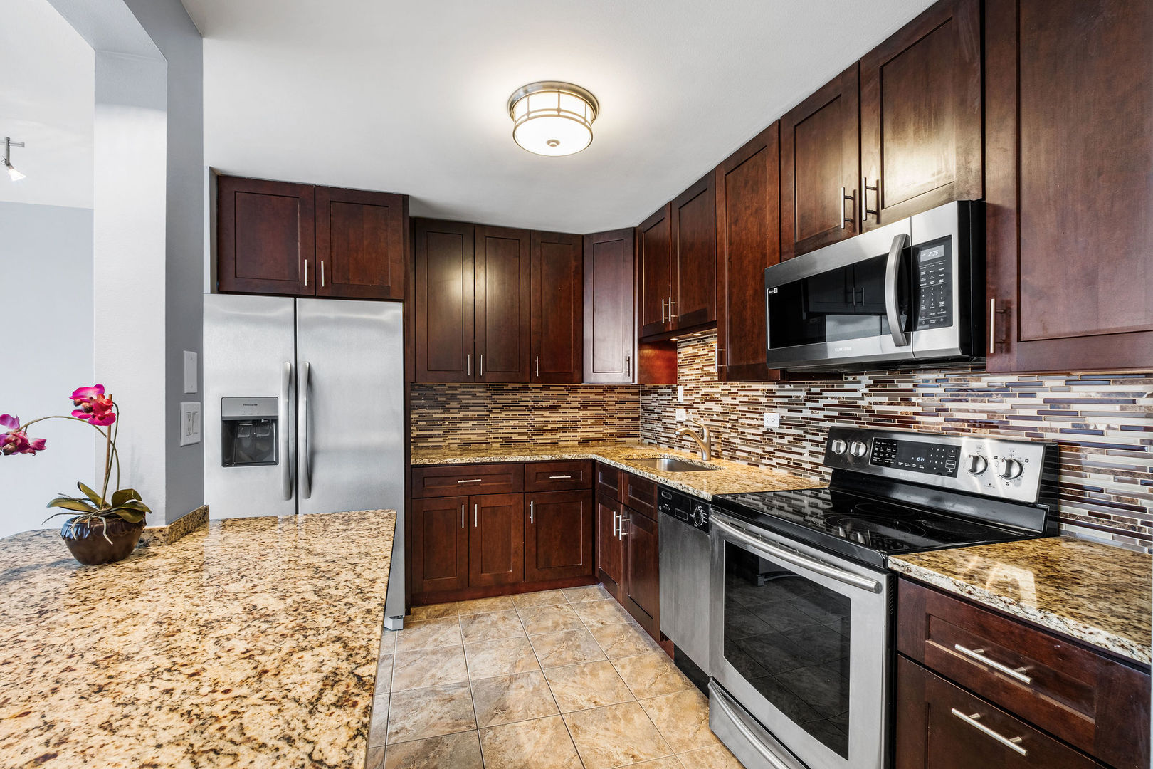 5455 North Sheridan Road, Unit 711 Chicago, IL 60640 - Photo 7 of 25 a kitchen with stainless steel appliances granite countertop a stove refrigerator and microwave