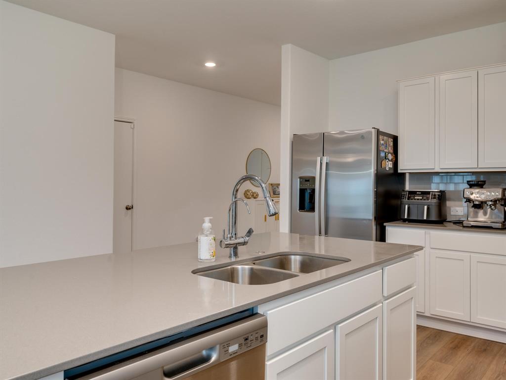 1208 Sweetspire Street Leander, TX 78641 - Photo 6 of 36 Kitchen island featuring a double basin stainless steel sink with a gooseneck faucet