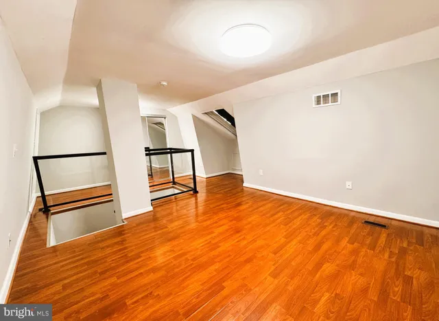a view of an empty room with wooden floor and floors