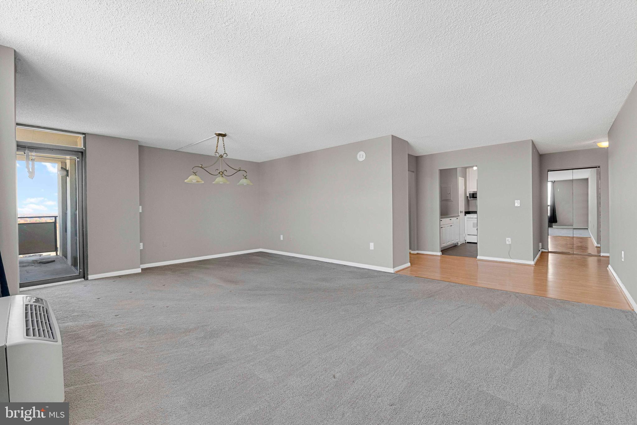 205 East Joppa Road, Unit 1902 Towson, MD 21286 - Photo 12 of 27 an empty room with large windows and a chandelier