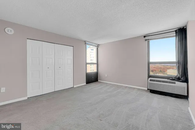 an empty room with sliding glass door and a window