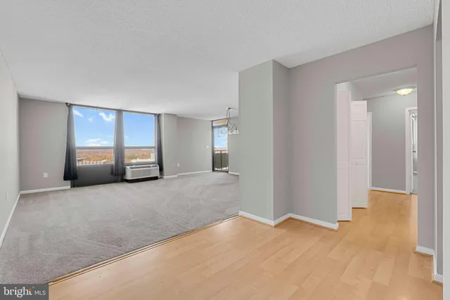 a view of empty room with window and wooden floor