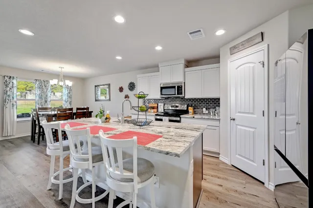 a view of a dining room with furniture wooden floor and chandelier