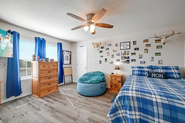 a bedroom with a bed a window and a dresser