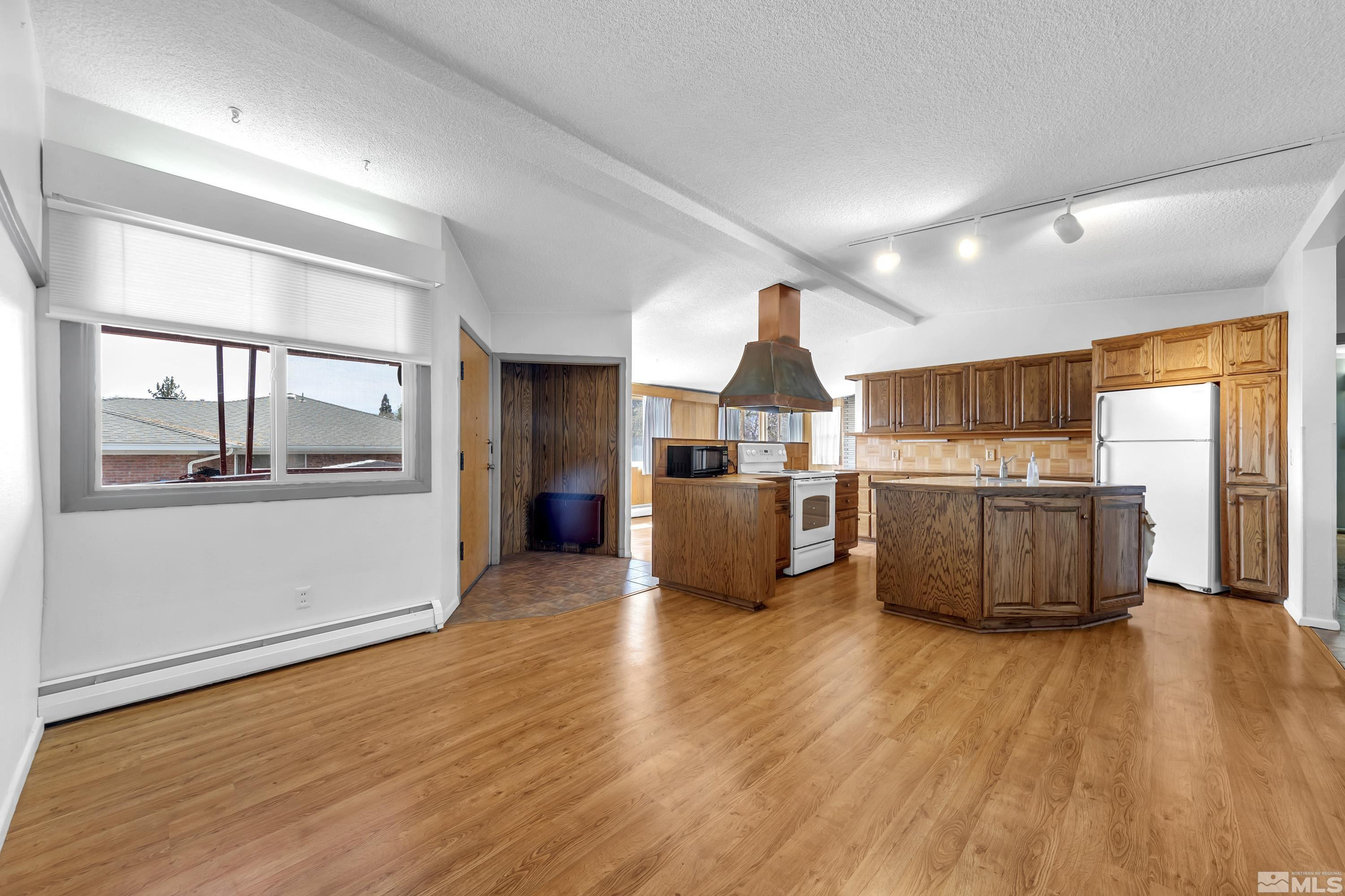 1275 Washington Street Reno, NV 89503 - Photo 6 of 37 a kitchen with stainless steel appliances a refrigerator and wooden floor