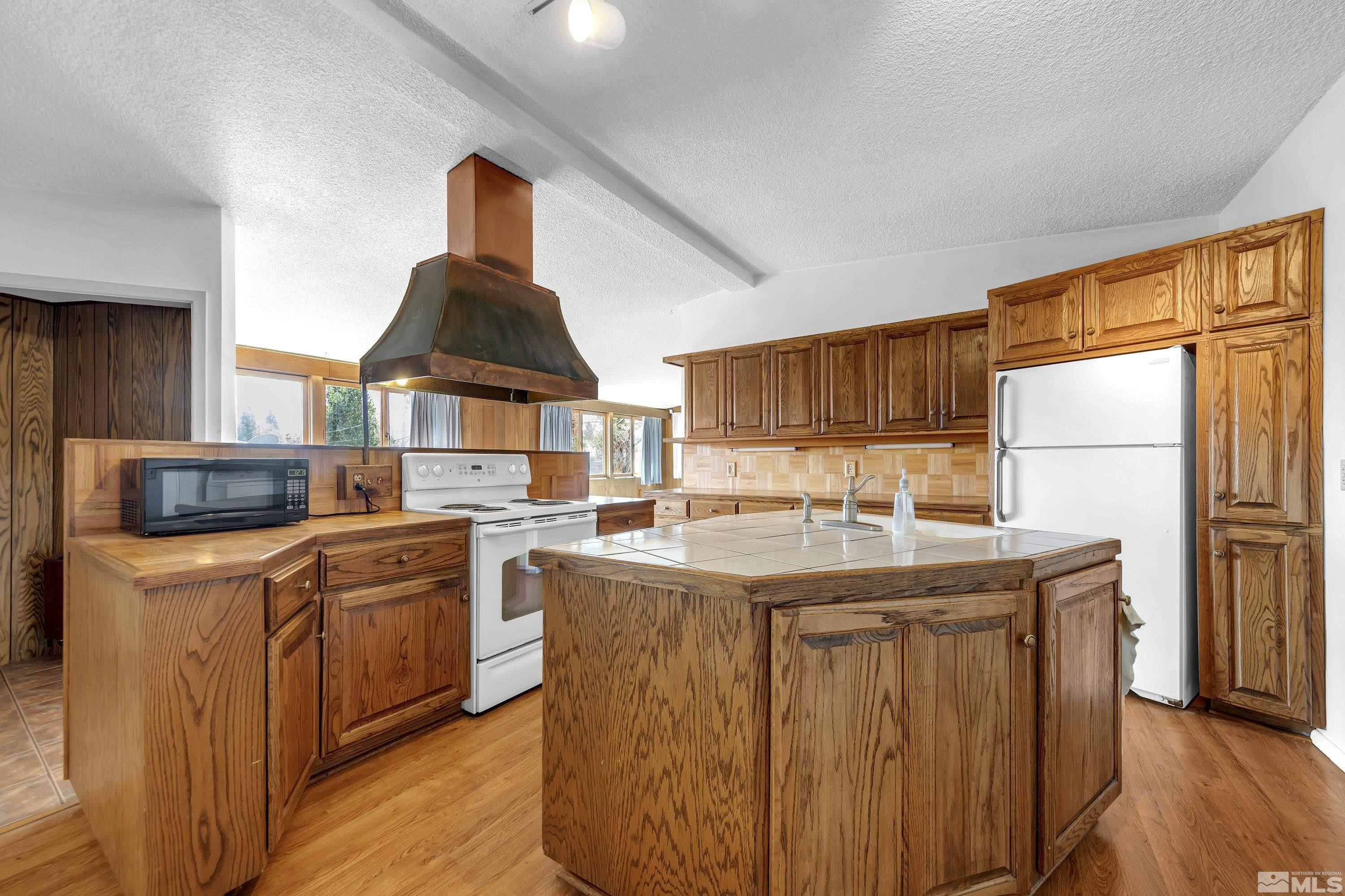 1275 Washington Street Reno, NV 89503 - Photo 7 of 37 a kitchen with stainless steel appliances granite countertop a stove and a refrigerator