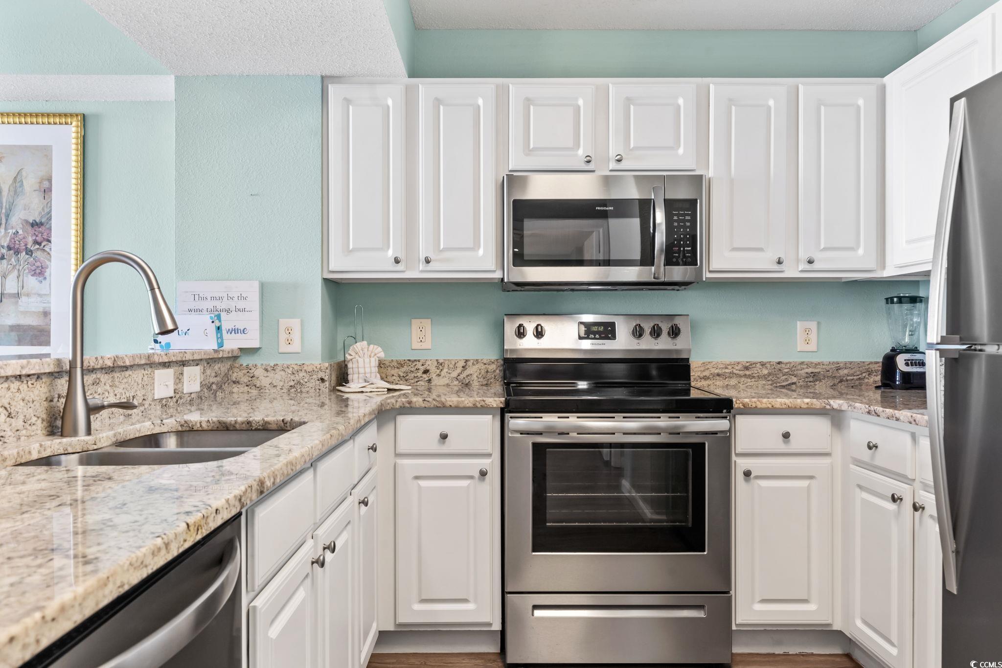 2007 South Ocean Boulevard, Unit 607 Myrtle Beach, SC 29577 - Photo 15 of 40 Kitchen with white cabinetry, light stone counters