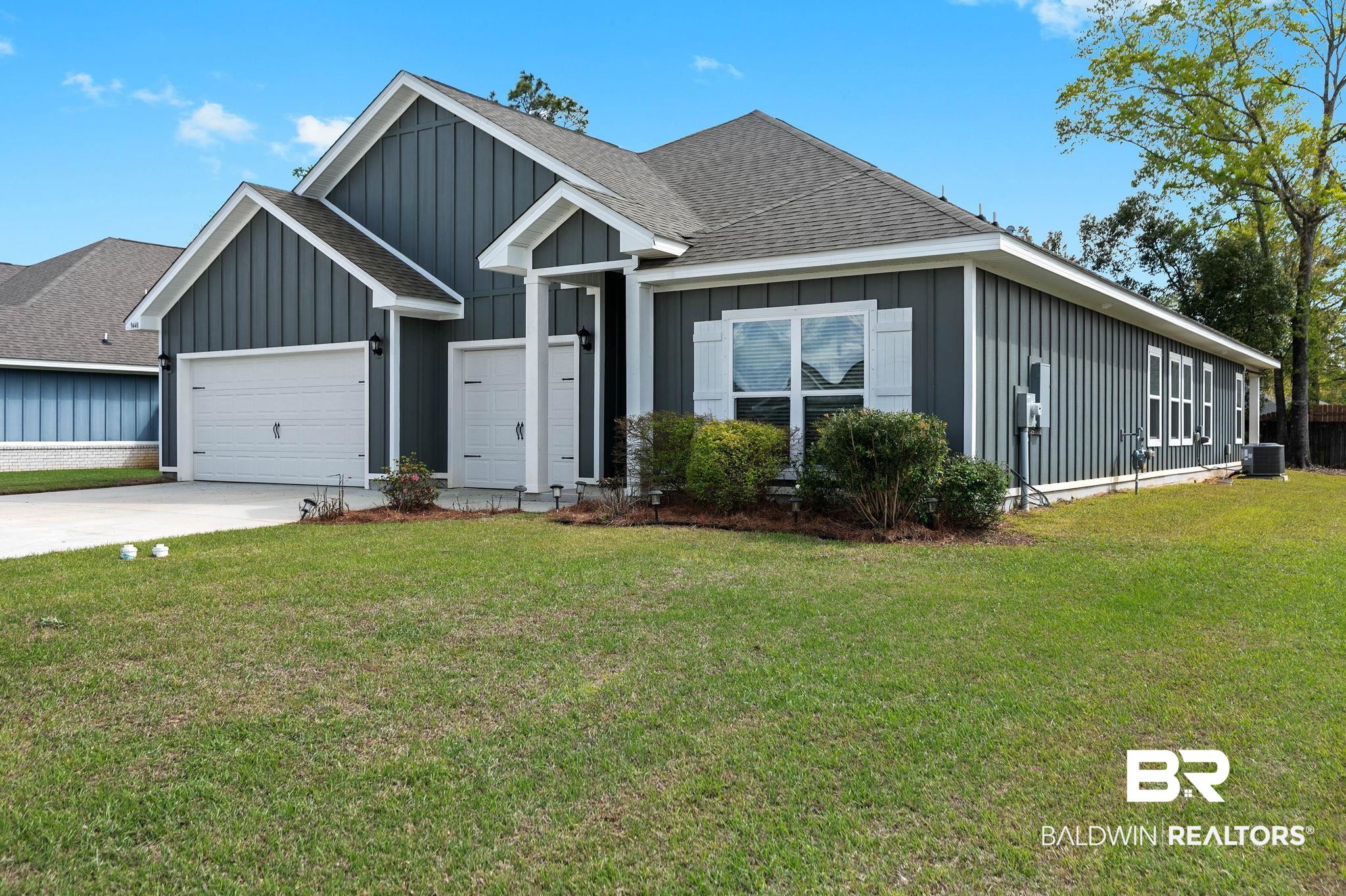 9448 Amethyst Drive Daphne, AL 36526 - Photo 2 of 61 View of front facade featuring board and batten siding, roof with shingles, a front yard, and concrete driveway