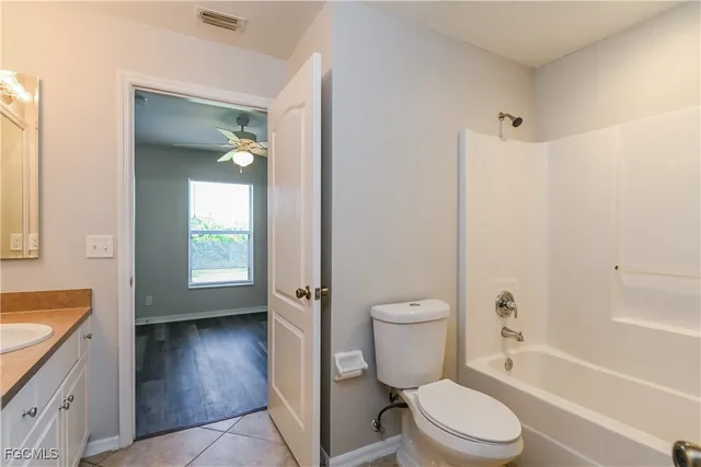 a bathroom with a granite countertop toilet a sink and bathtub