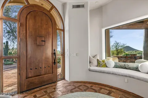 a living room with fireplace furniture and a large window