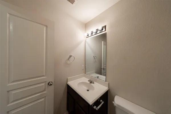 a bathroom with a sink a toilet and mirror