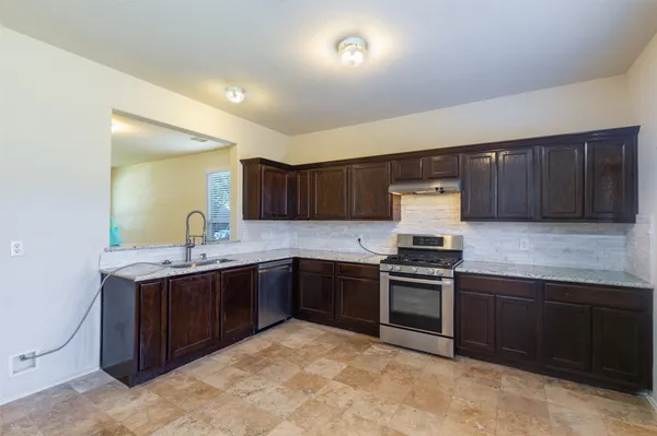 a kitchen with stainless steel appliances granite countertop a stove sink and cabinets