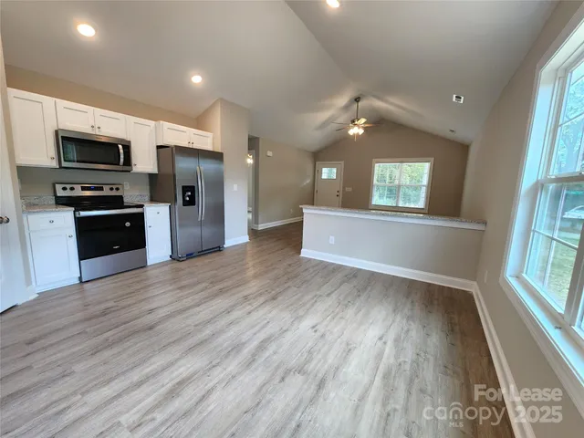 wooden floor in kitchen and an empty room with wooden floor and a kitchen