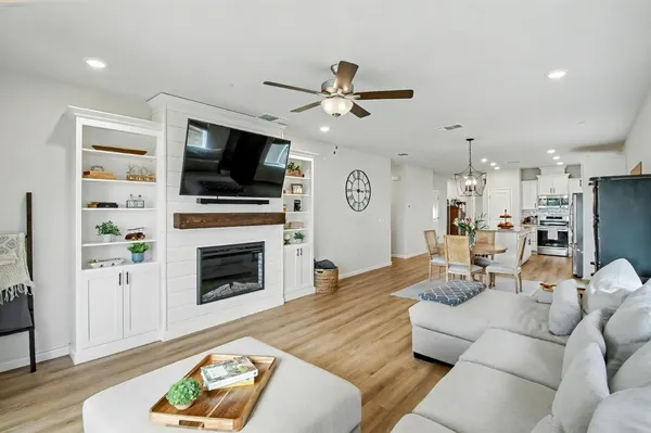 a living room with furniture a flat screen tv and a fireplace
