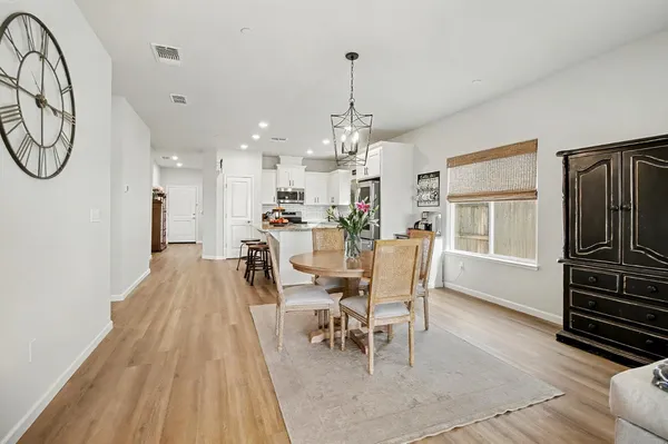 a dining room with furniture a chandelier and wooden floor