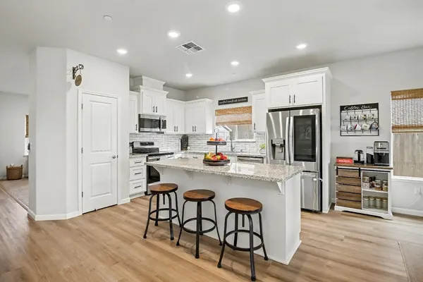 a kitchen with stainless steel appliances a refrigerator and a stove top oven