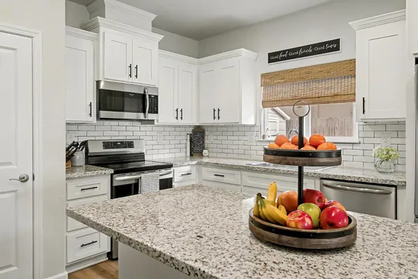 a kitchen with a microwave a stove and cabinets