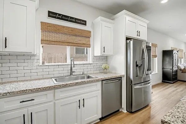 a kitchen with stainless steel appliances granite countertop a refrigerator and a sink